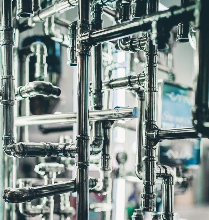 Close-up of complex stainless steel pipes in an industrial setting, showcasing modern engineering.